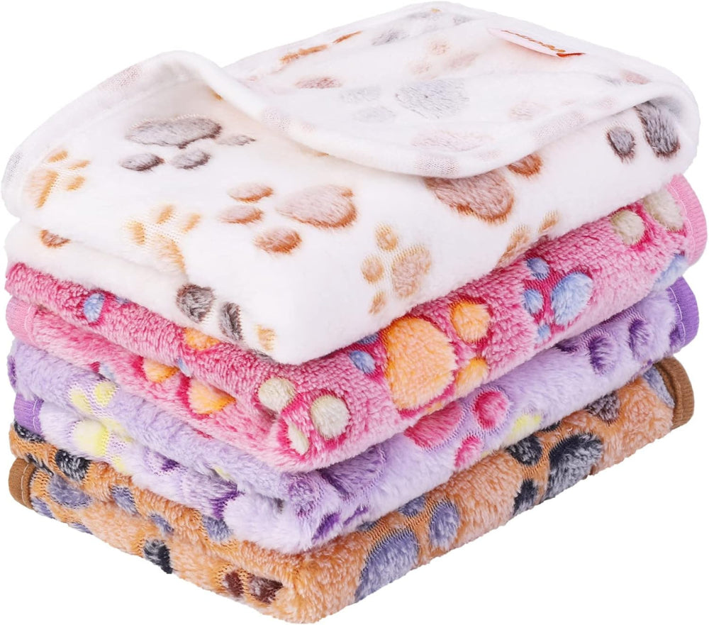 Stack of colorful fleece blankets with paw prints on a white background